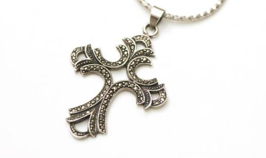 Srebrny krzyżyk z grawerem jako symbol miłości i przyjaźni