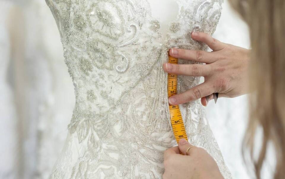 Jak dopasować suknię ślubną po zakupie gotowego modelu — kiedy wystarczą poprawki krawieckie